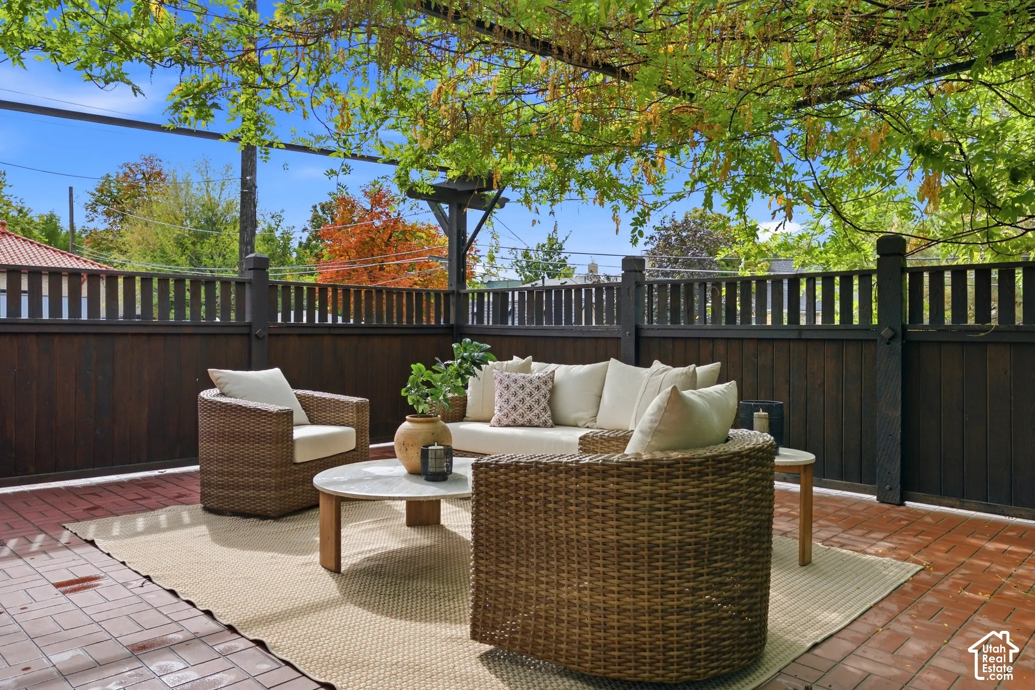 Expansive outdoor patio with a brick-finish surface and a slatted privacy fence