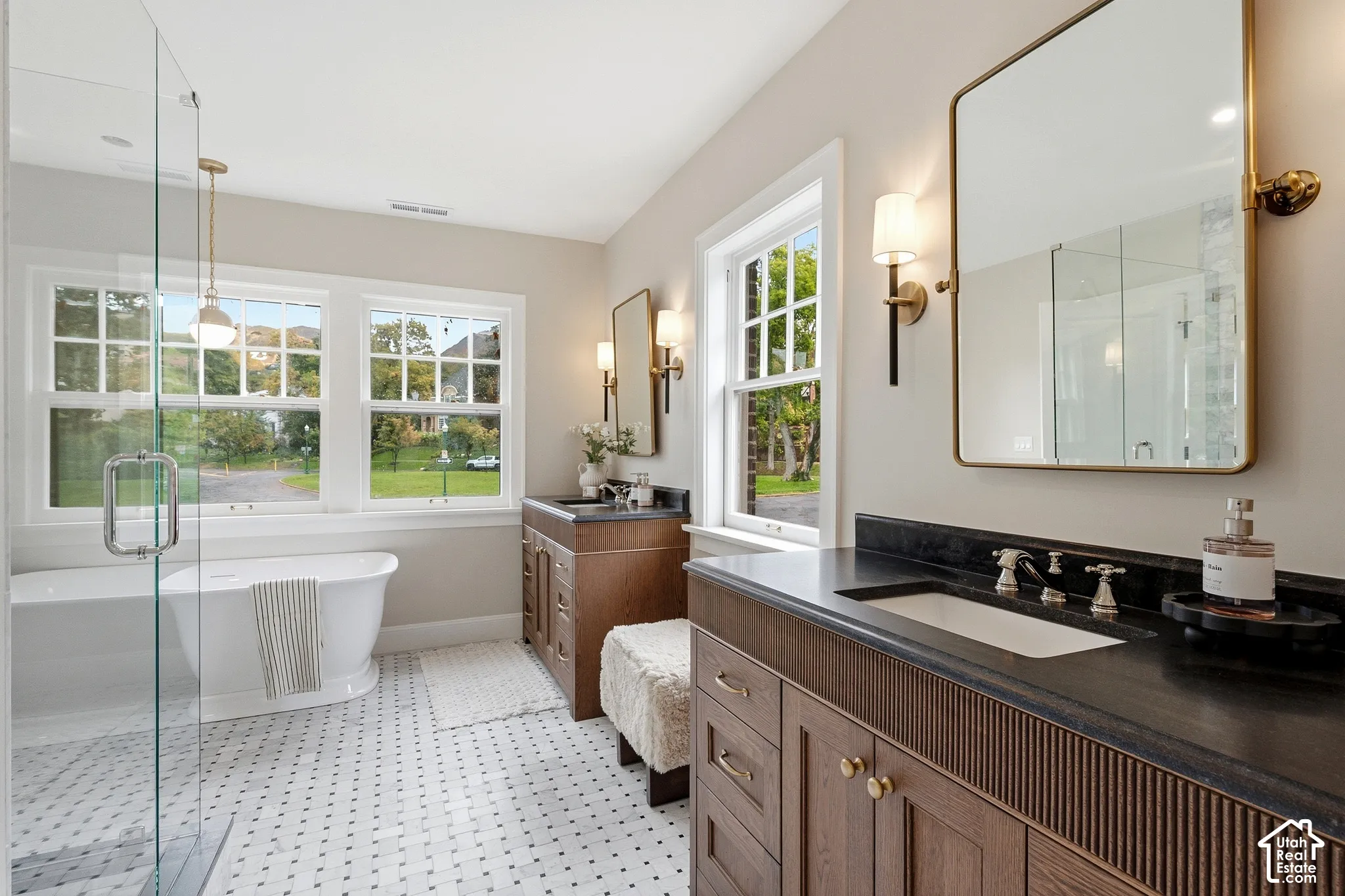 Primary bathroom featuring two custom vanities, a beautiful freestanding bathtub and Black Mist stone countertops