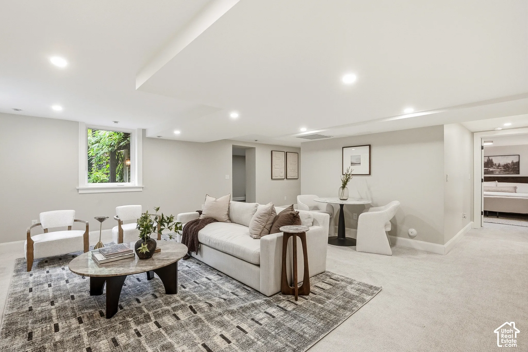 Recessed lighting illuminates the living room with  additional seating area for two