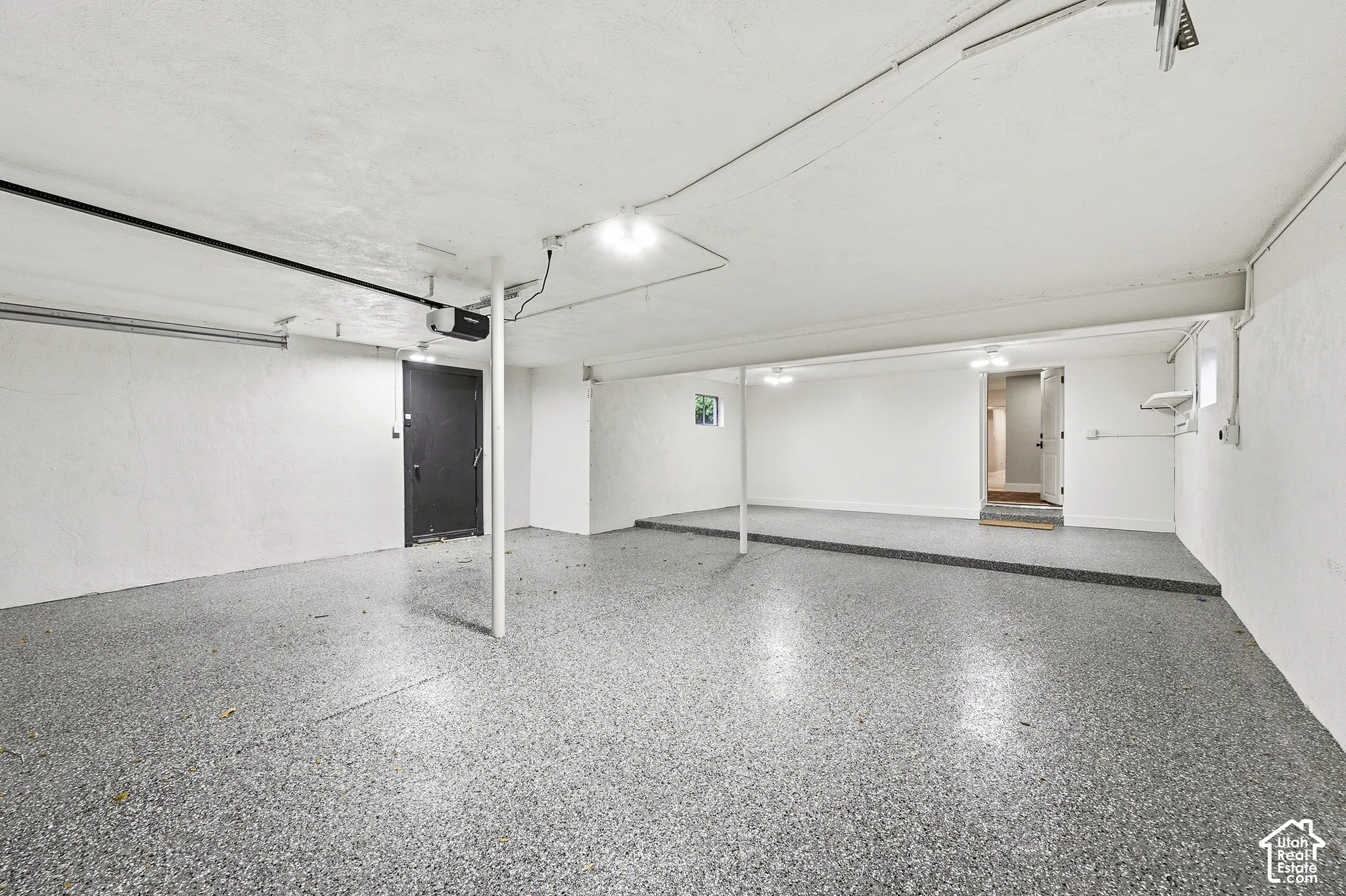 Spacious garage with epoxy flooring and overhead lighting