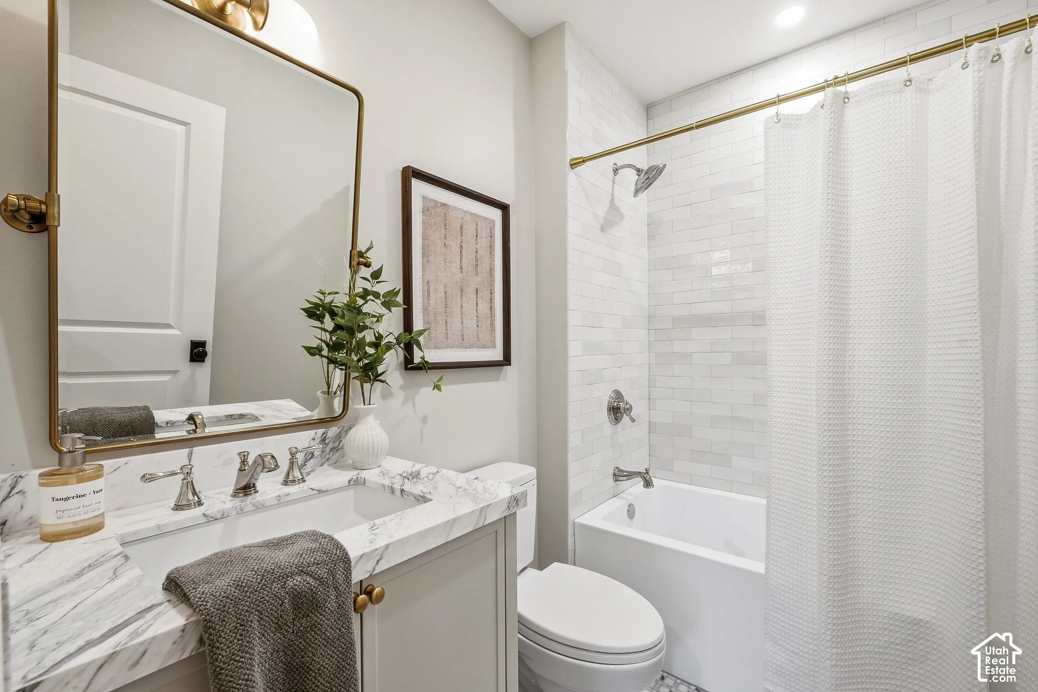 Hallway Full Bath. Marble-finish vanity with an undermount sink and brushed nickel faucet