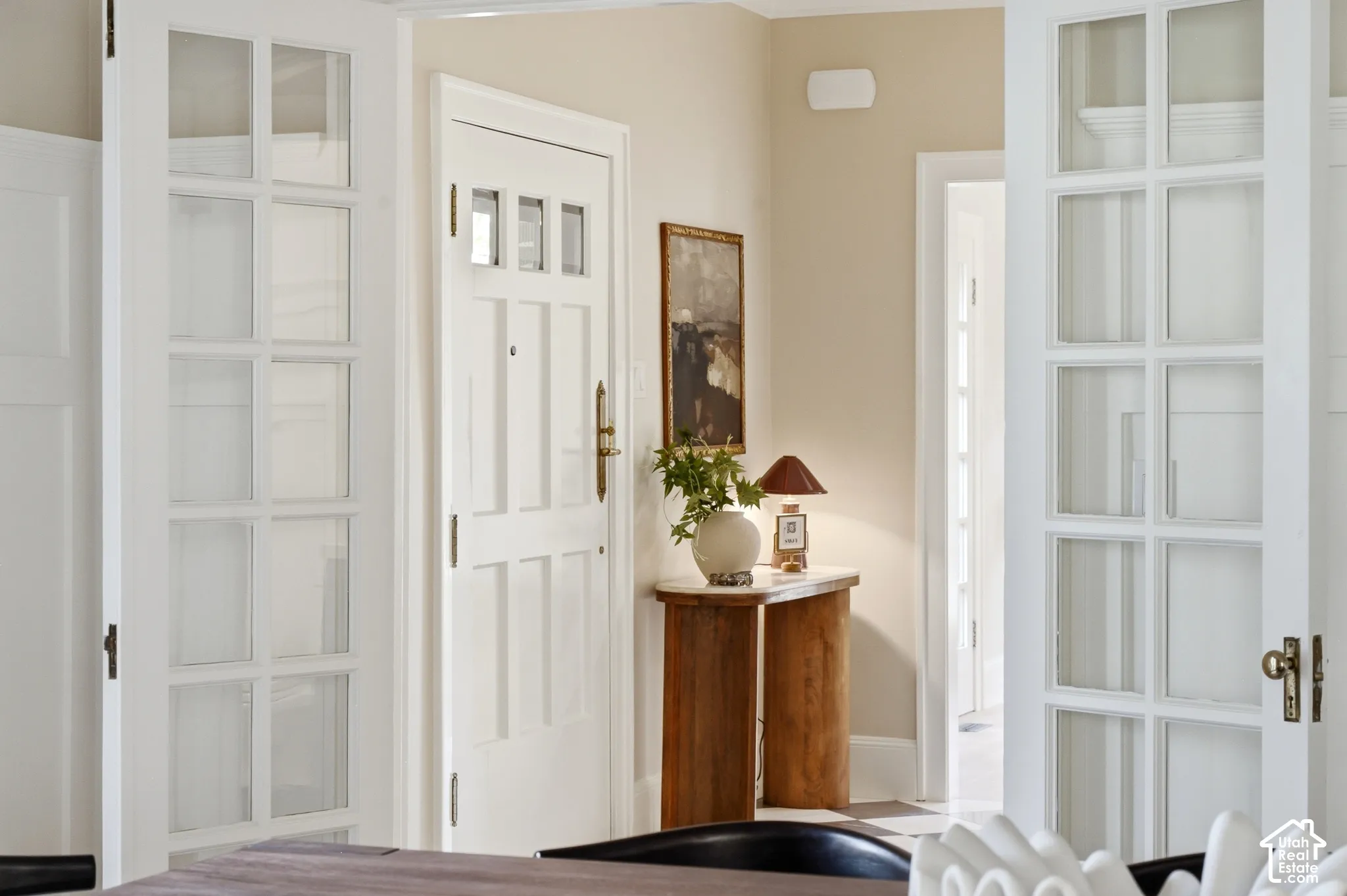 White paneled interior doors, light-colored wall paint, and natural wood-finish console table
