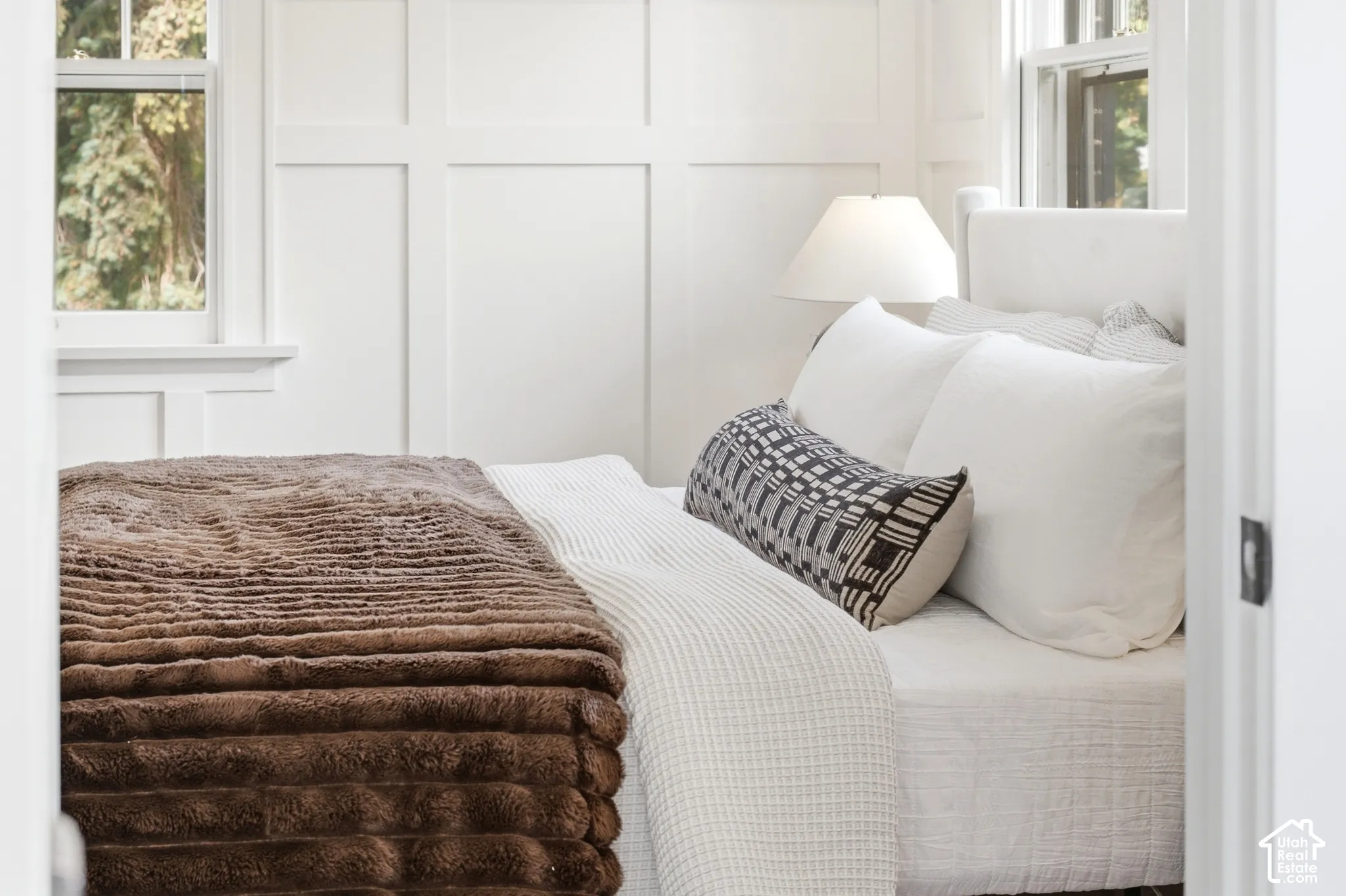Primary bedroom with white paneled walls and beautiful views outside