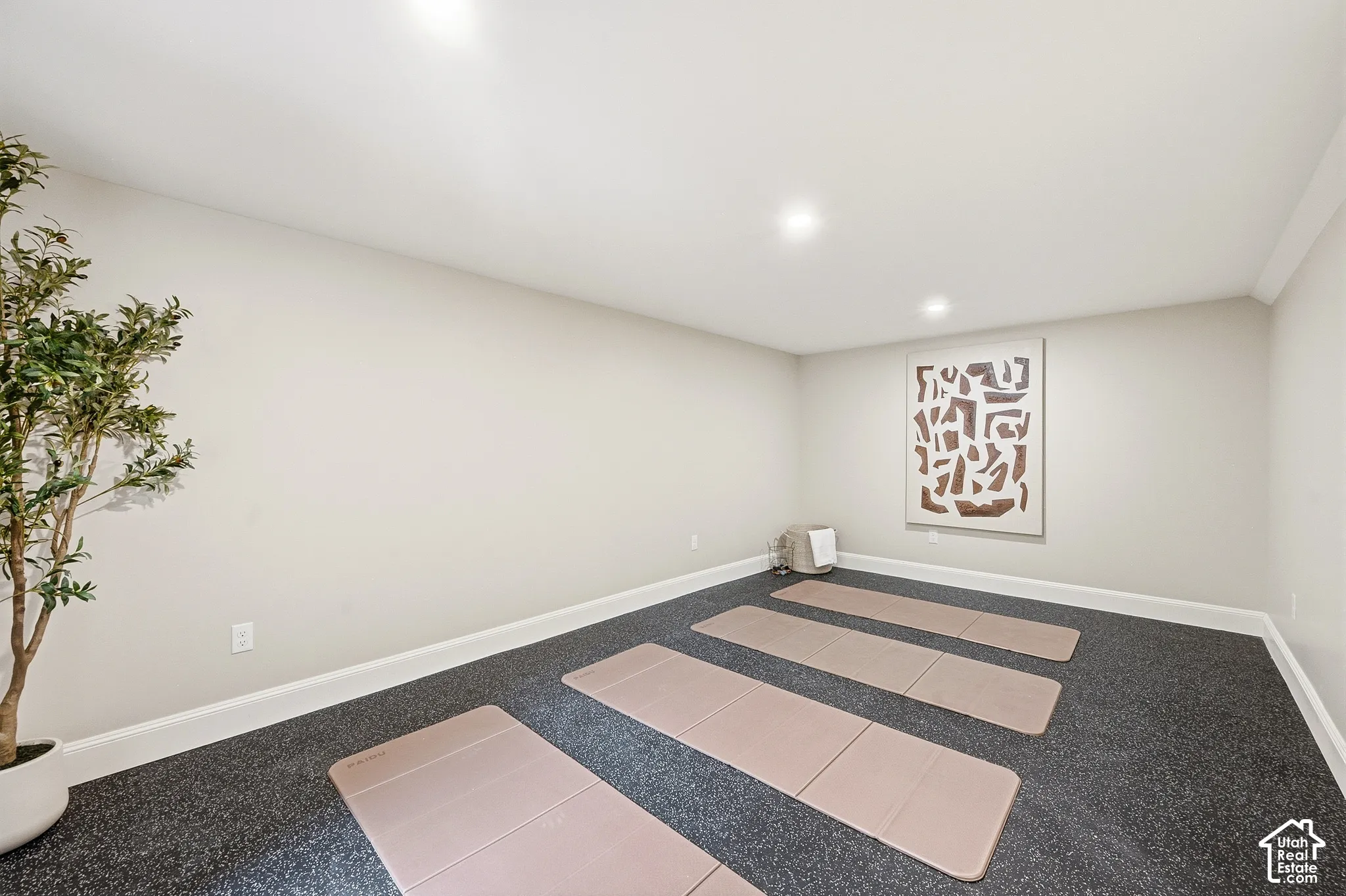 Recessed lighting, light-toned wall paint, dark-toned flooring, white crown molding, and white baseboards