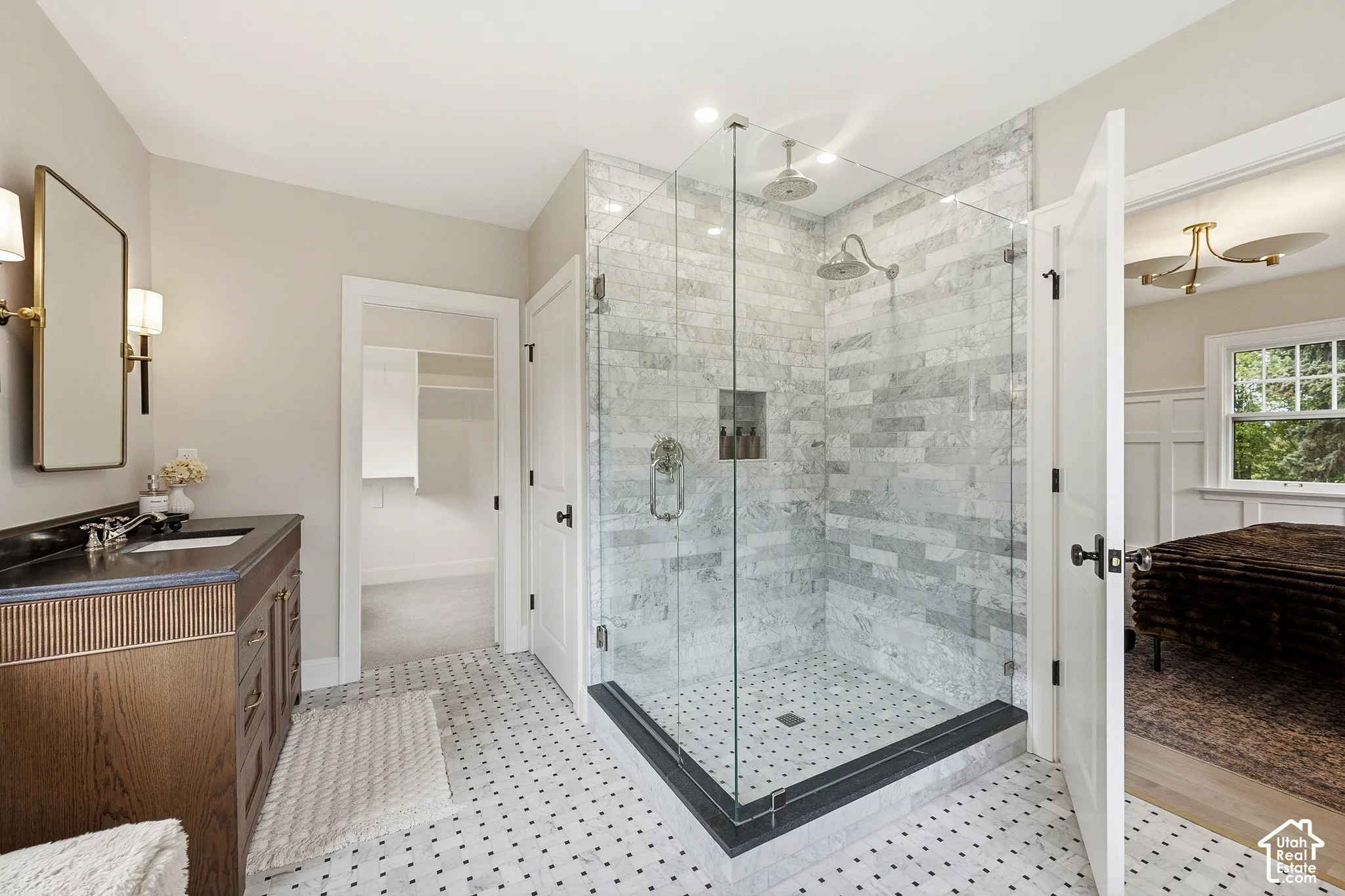 Glass-enclosed shower with marble surround and dual shower heads