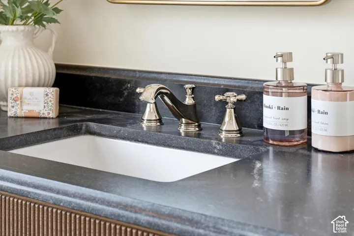 Integrated white rectangular sink with a three-piece polished nickel faucet set, set within a dark stone countertop