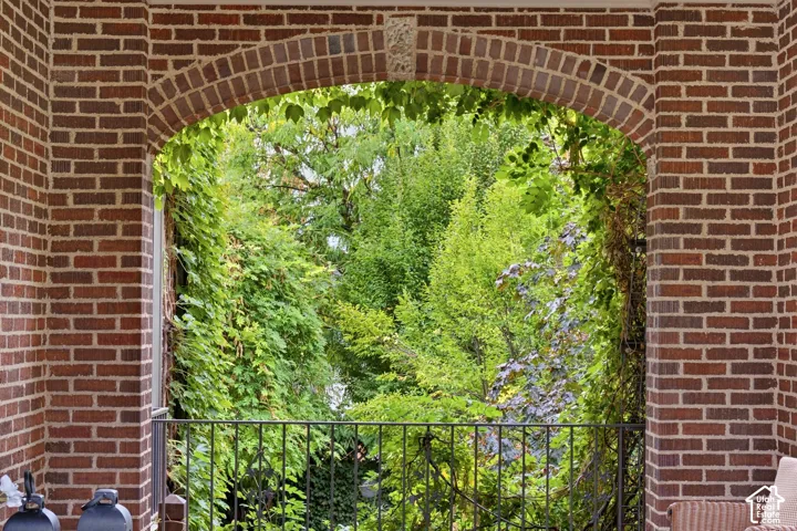 Brick archway featuring a decorative keystone and wrought iron railing
