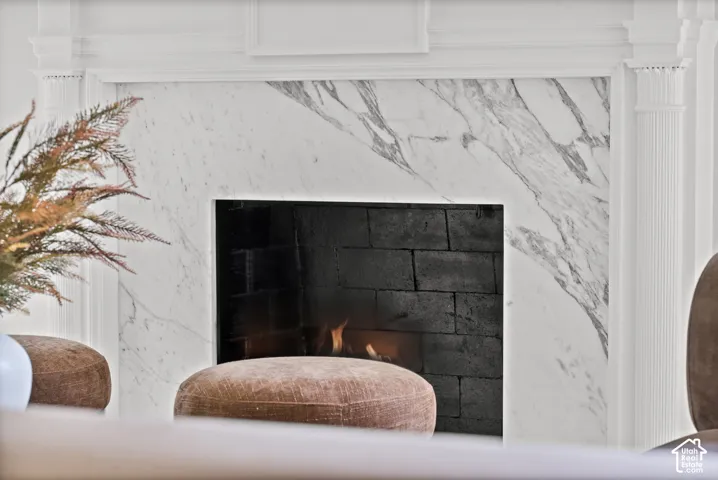 Fireplace with a white marble surround, original classic mantel molding, and fluted column detailing