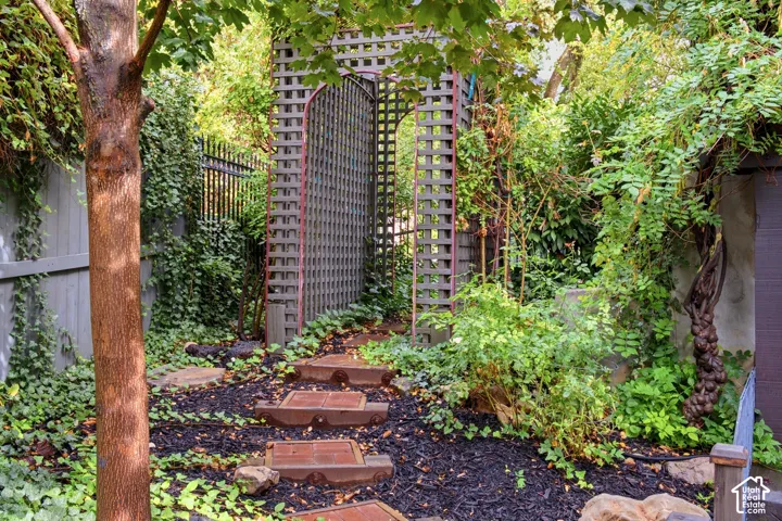 Landscaped garden pathway featuring stepping stones and decorative lattice archway
