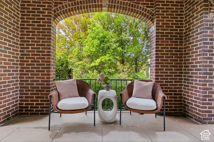 Brick archway with an exterior brick wall, furnished with a cozy seating area