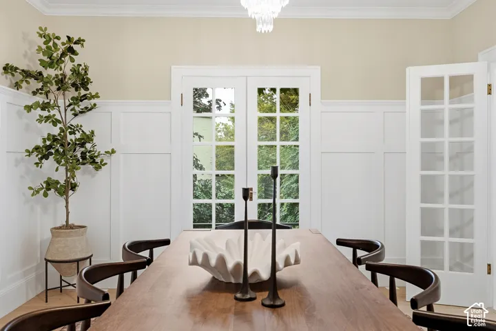 White wainscoting paneling with crown molding with views toward private gardens