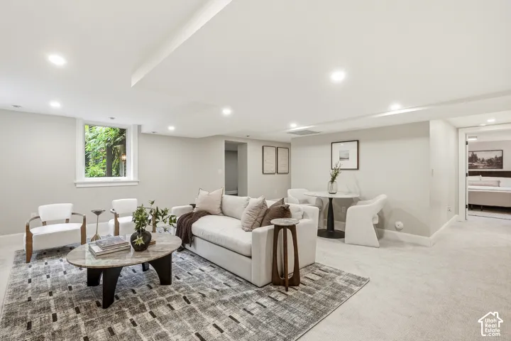 Recessed lighting illuminates the living room with  additional seating area for two