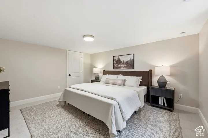 Carpeted flooring, recessed ceiling lighting, light-toned wall paint, white trim, and a paneled door with dark hardware