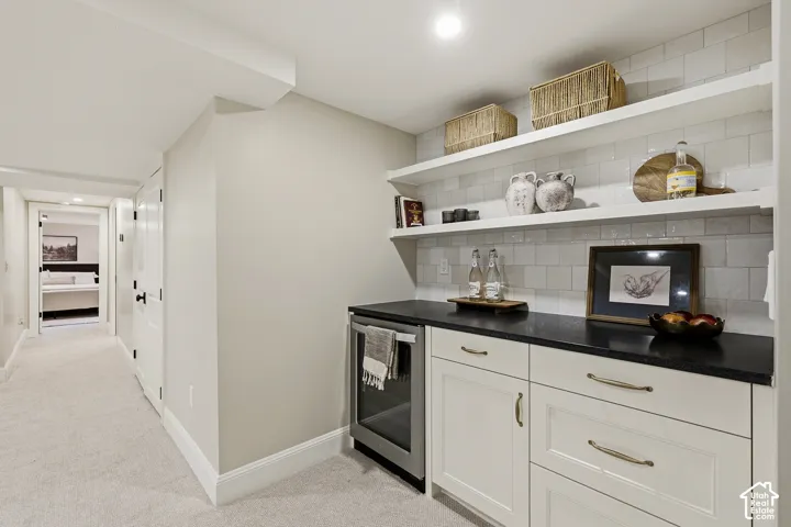 Custom cabinetry with gold-tone hardware, dark countertop, and built-in beverage cooler