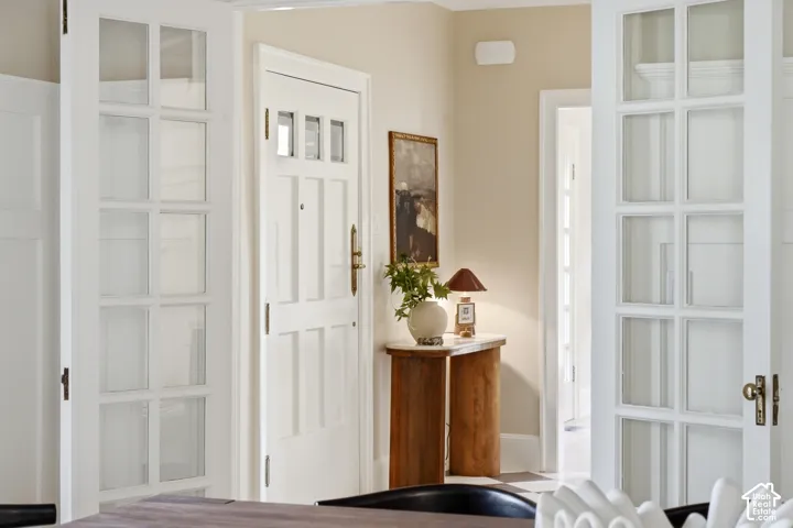 White paneled interior doors, light-colored wall paint, and natural wood-finish console table