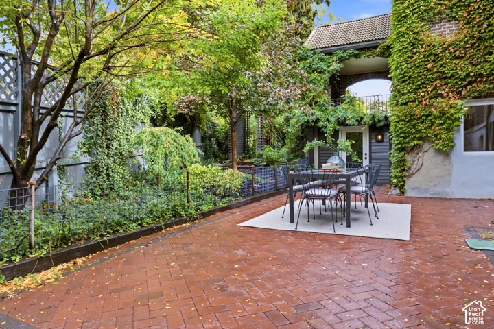 Brick paver patio with a lattice fence and mature landscaping