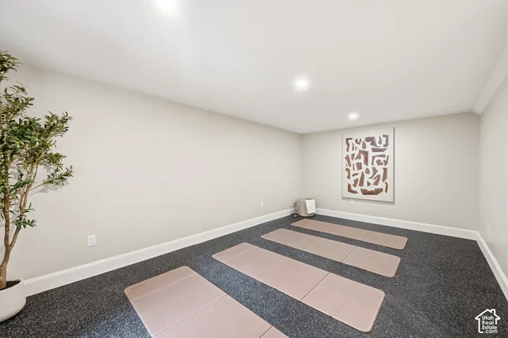 Recessed lighting, light-toned wall paint, dark-toned flooring, white crown molding, and white baseboards