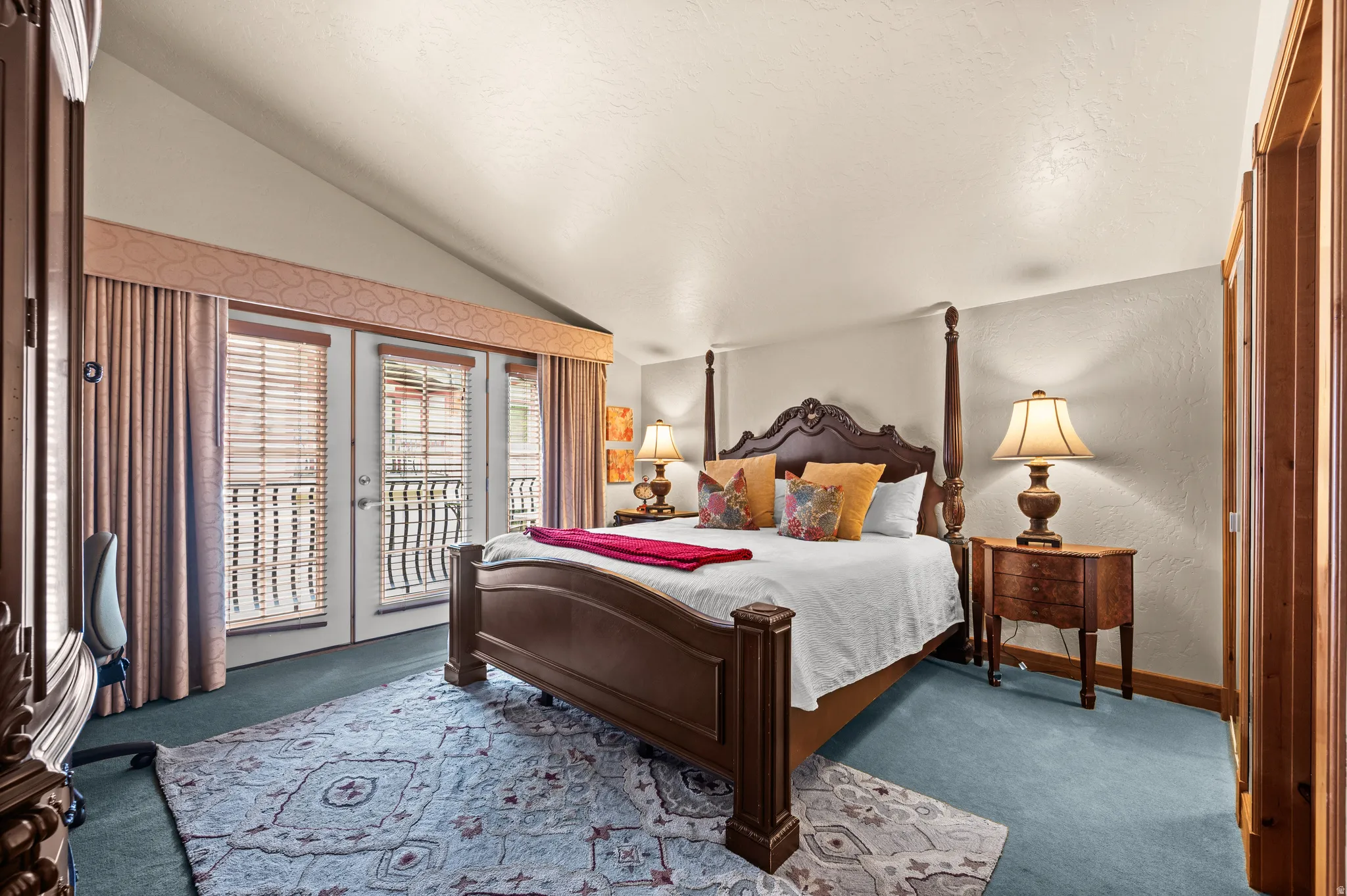 Vaulted ceiling, direct balcony access, wood-finish doors, wood-finish trim, and carpet flooring