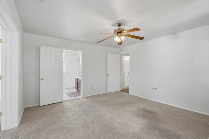 Carpeted flooring, white interior doors, ceiling fan with integrated lighting, recessed lighting, and white wall finishes