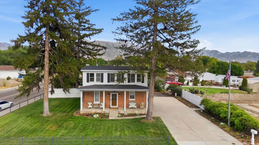 Brick-front residence with a two-story elevation, covered porch, and mature landscaping