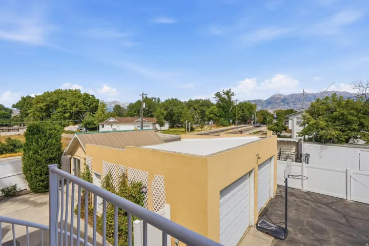 Detached garage with two roll-up doors, asphalt driveway, and mountain backdrop