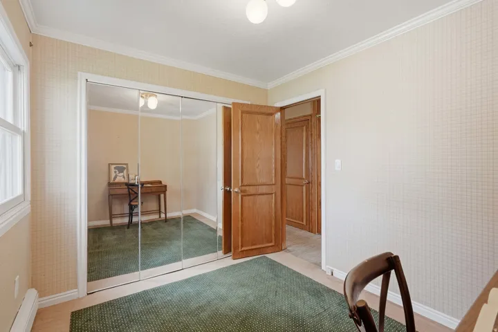 Mirrored sliding closet doors, wood-paneled interior doors, and crown molding