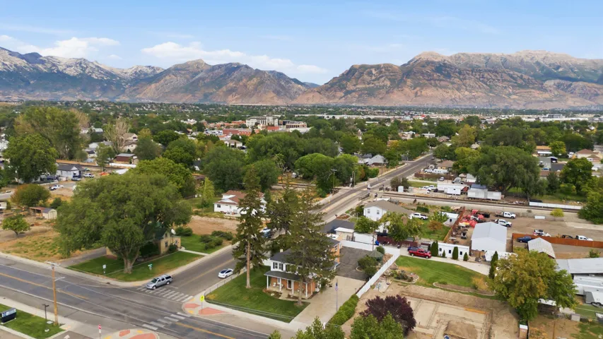 Expansive neighborhood setting featuring mature trees, residential properties, and distant mountain ranges