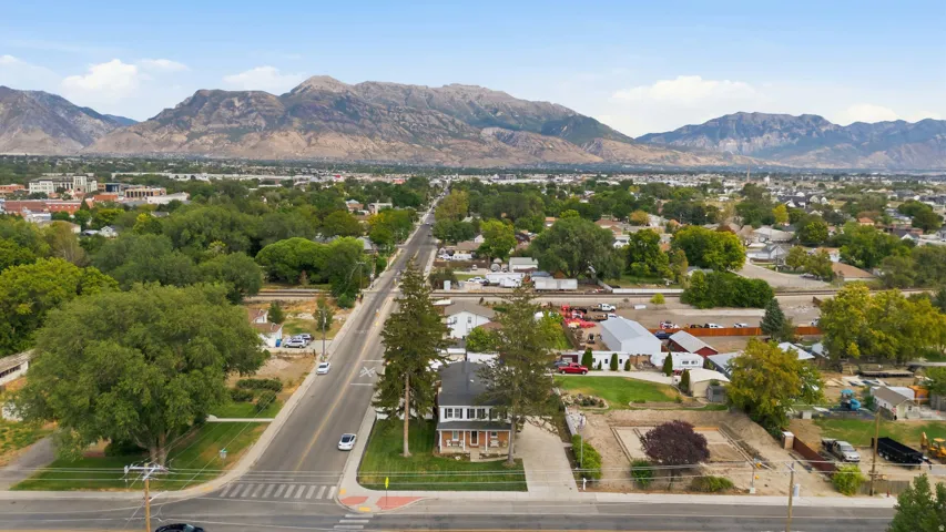 Mountain backdrop, mature trees, residential street, mixed-use buildings, established neighborhood