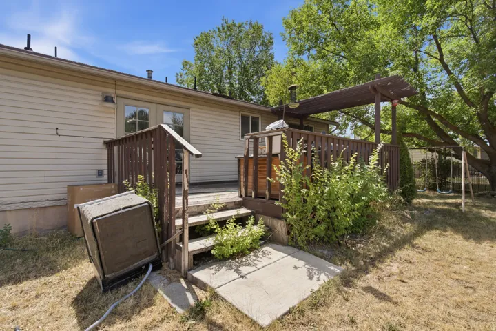 Rear deck with pergola, wood railings, and concrete pad