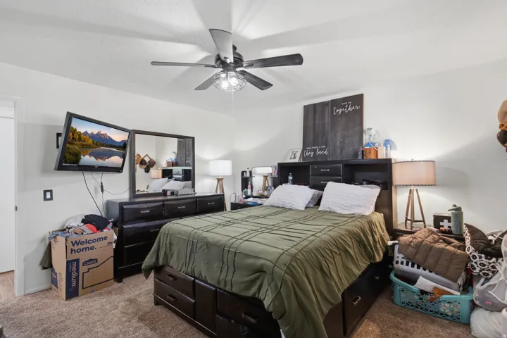 Primary Bedroom featuring a ceiling fan with integrated lighting, and carpeted flooring throughout