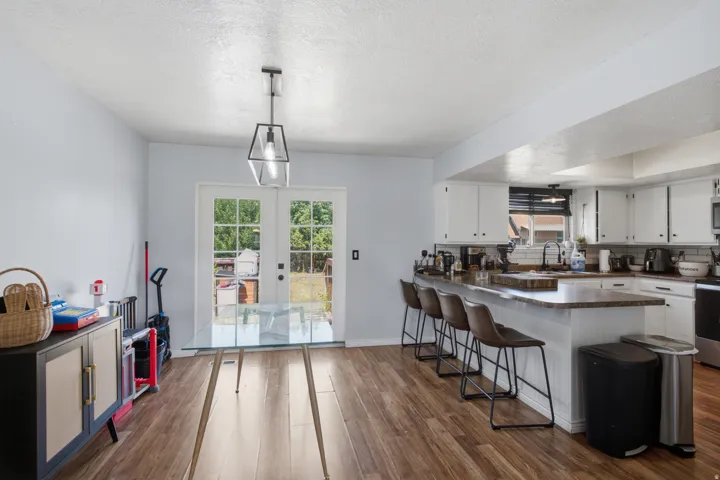 Kitchen featuring white cabinetry, dark countertops, and wood-finish flooring