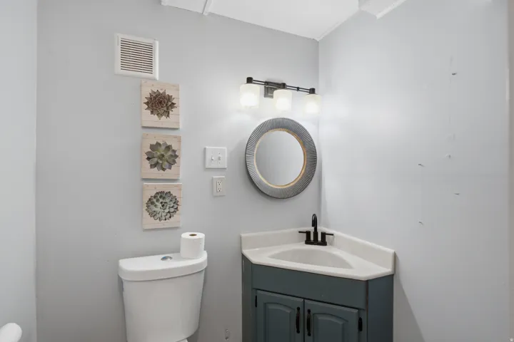 Corner vanity with a single basin, black faucet, and cabinet storage
