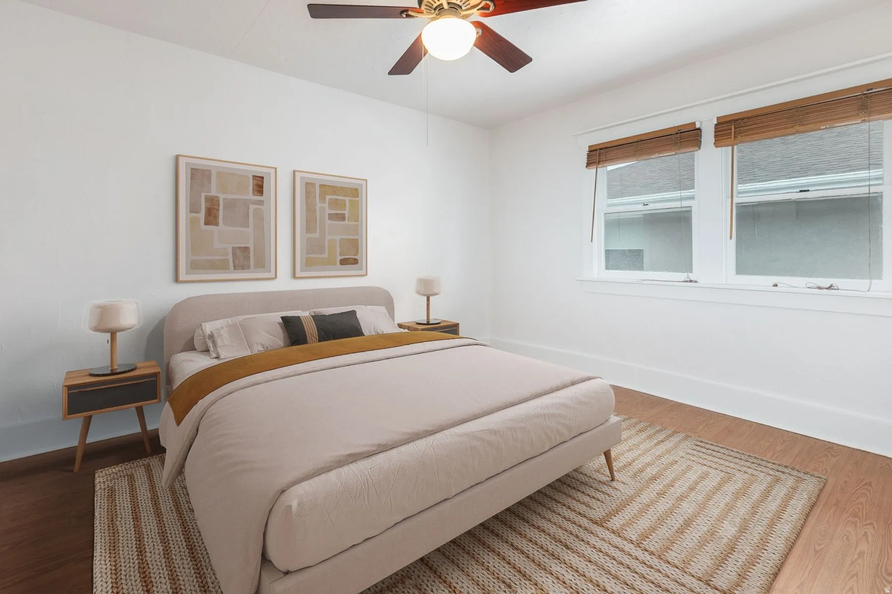 Room with wood-finish flooring, white walls, and a ceiling fan with integrated lighting