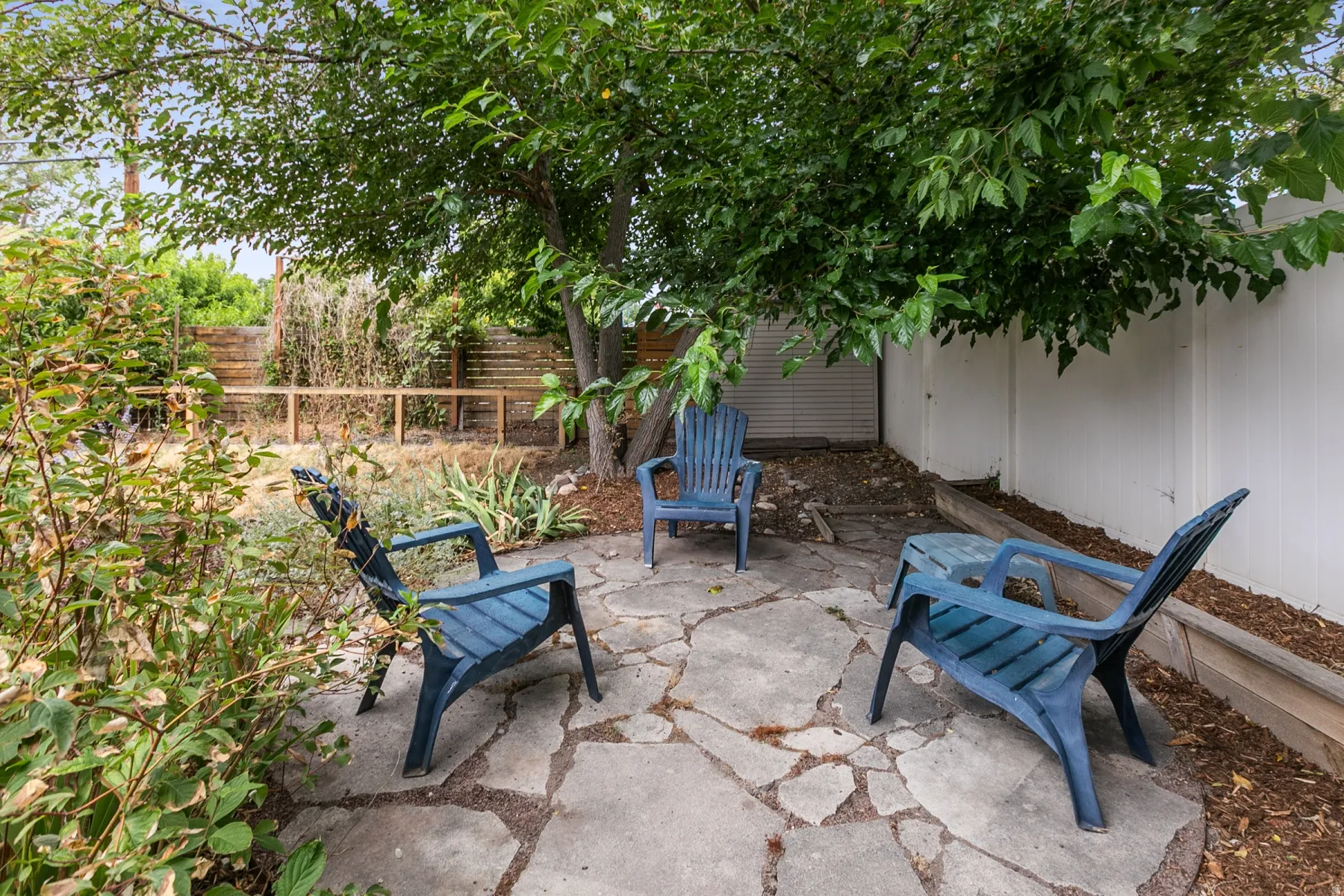 Flagstone patio with a mature tree providing natural shade
