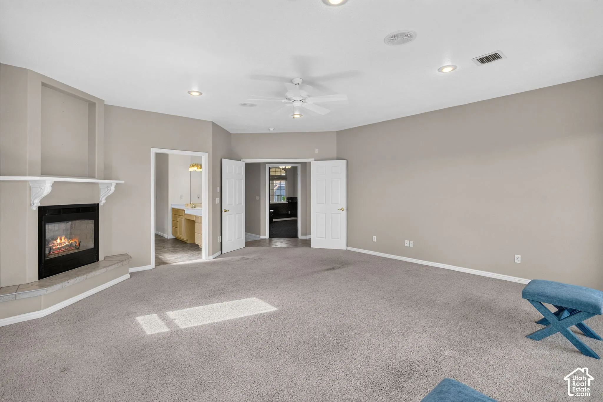 Spacious room featuring a fireplace with a mantel, ceiling fan, and recessed lighting