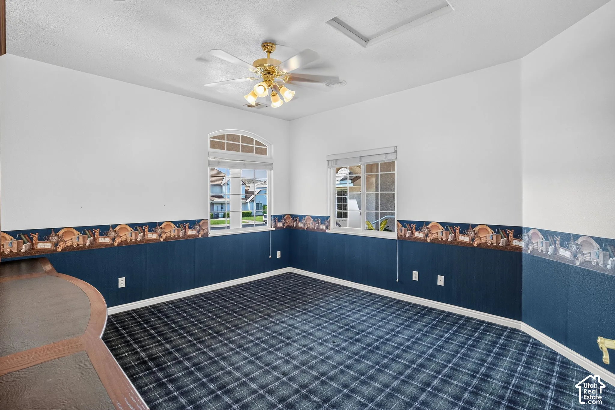 Arch-top window, ceiling fan, tartan pattern carpet, built-in desk, white trim