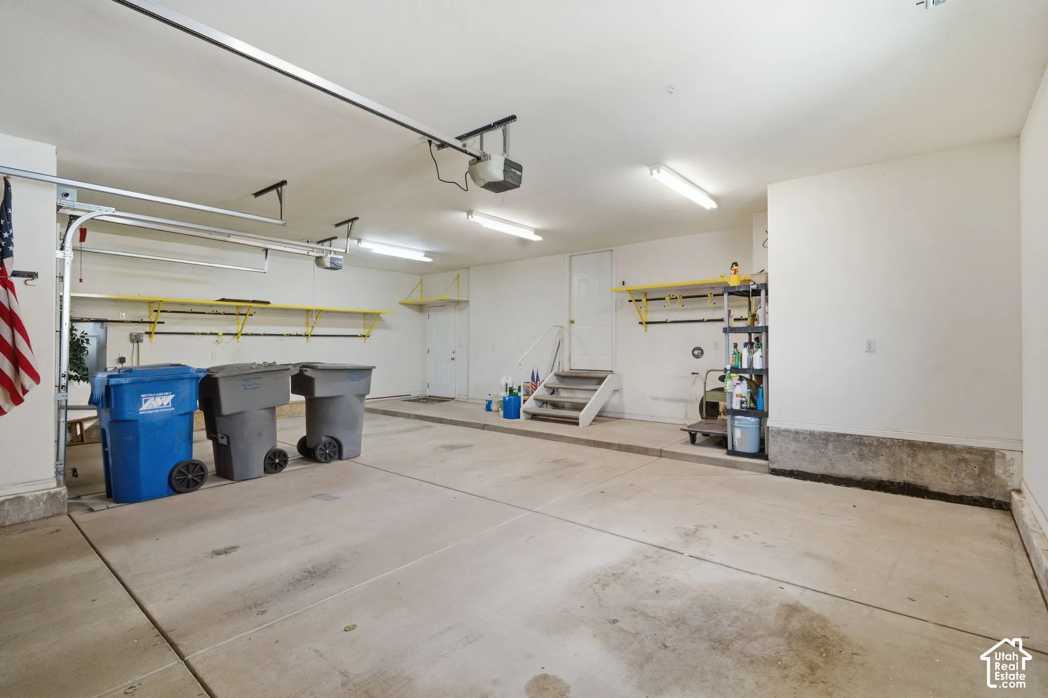 Spacious garage featuring concrete flooring and exposed ceiling beams