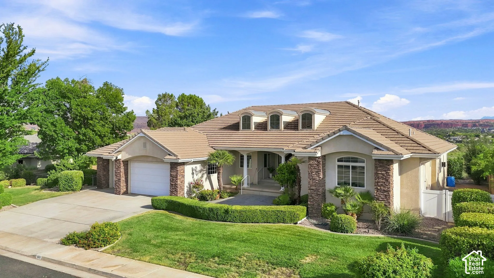 Stone-accented exterior with a tiled roof, multiple dormer windows, and an arched entry