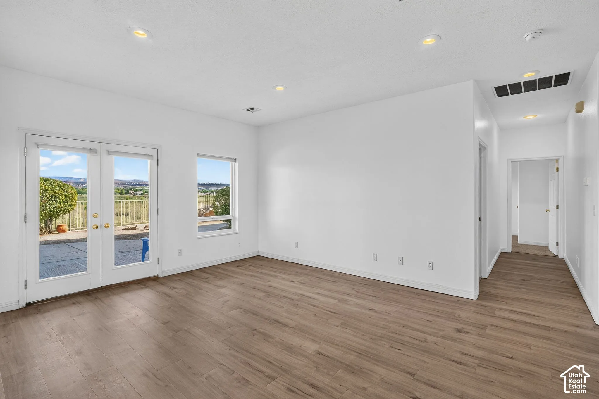 Wood-finish flooring, recessed lighting, and white walls with baseboards