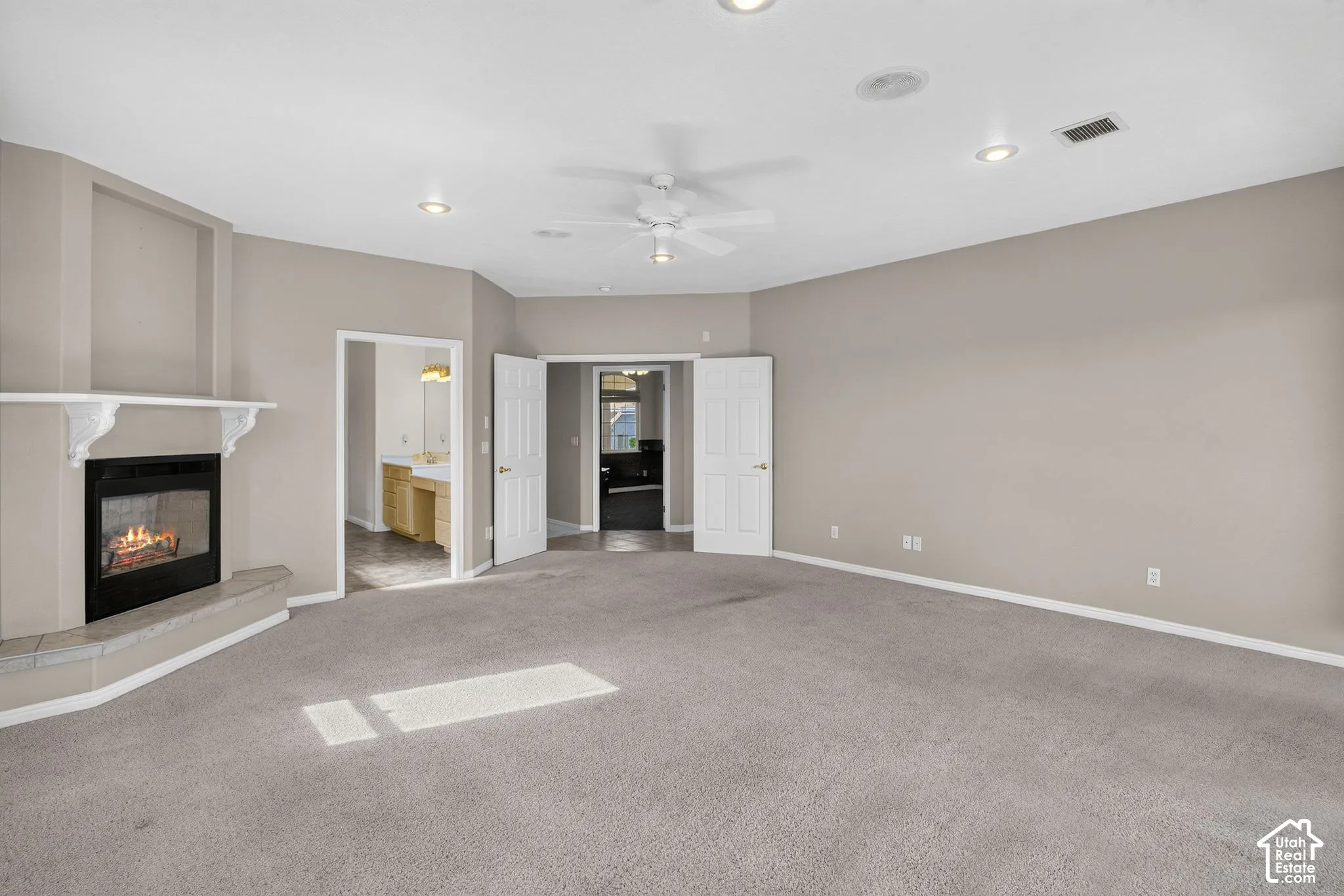 Spacious primary living area with neutral wall finishes, ceiling fan, and recessed lighting throughout