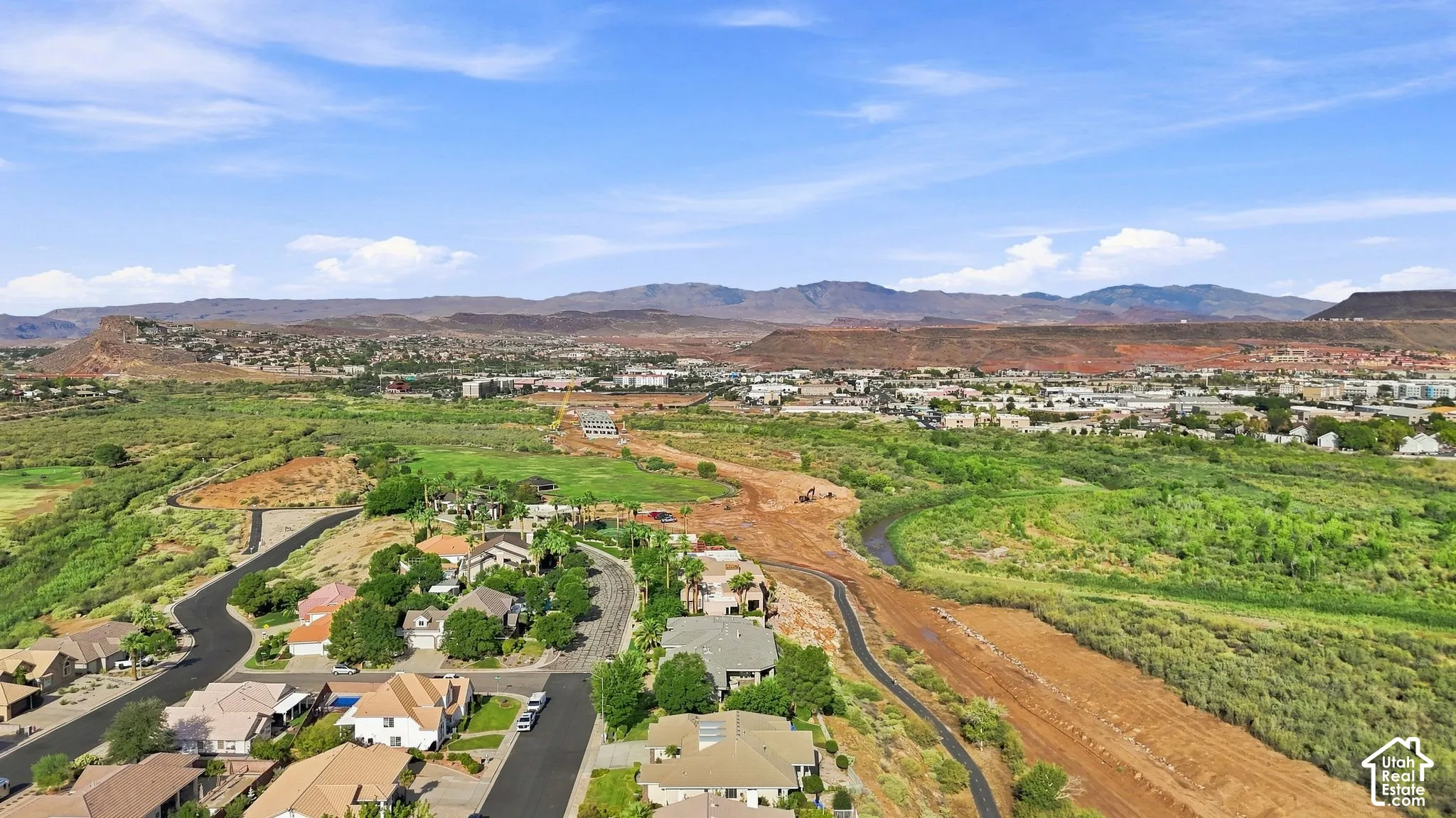 Residential neighborhood featuring winding streets, established landscaping, and distant mountain ranges