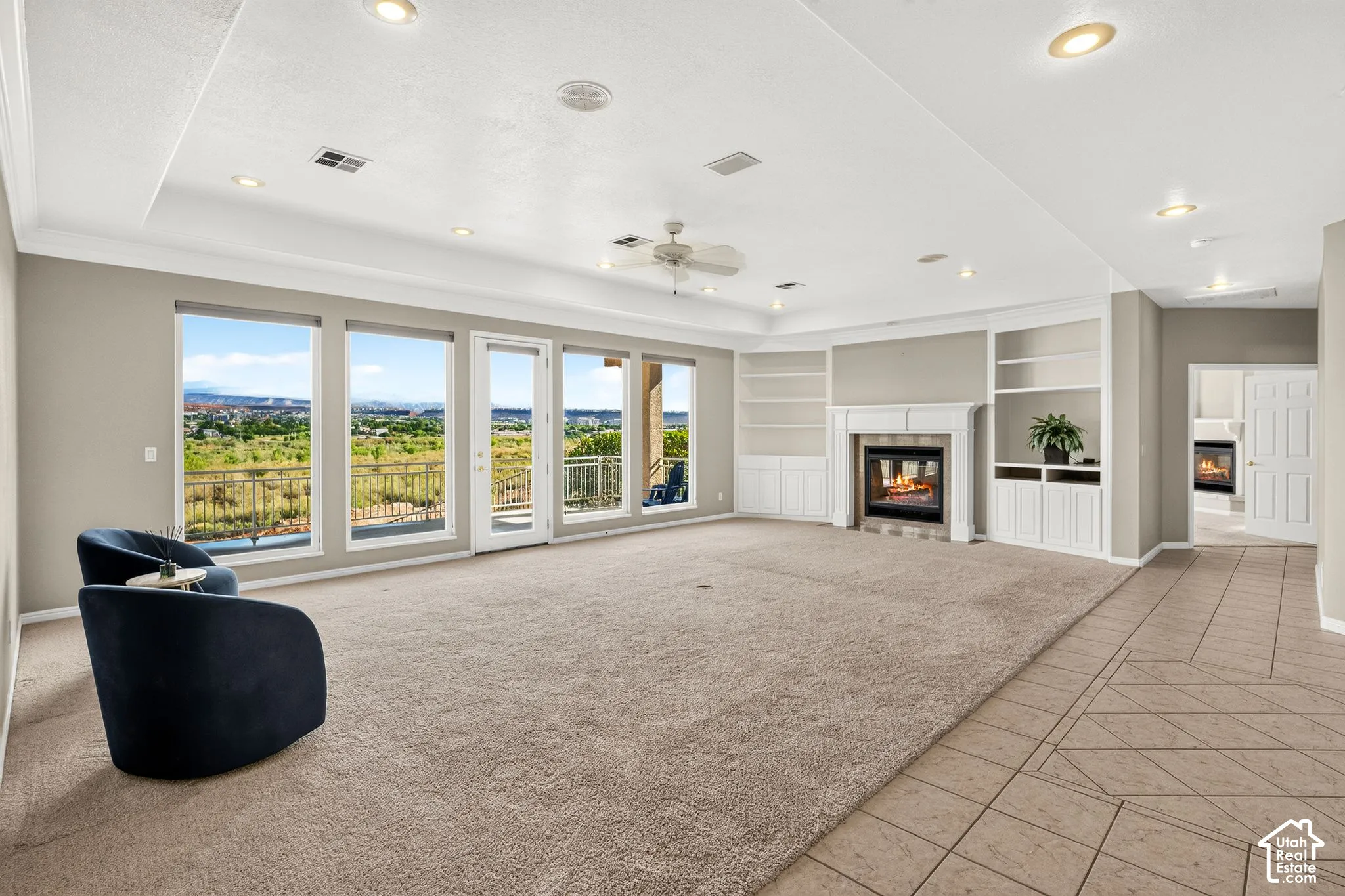 Spacious interior featuring a built-in fireplace, custom shelving, recessed lighting, and expansive windows