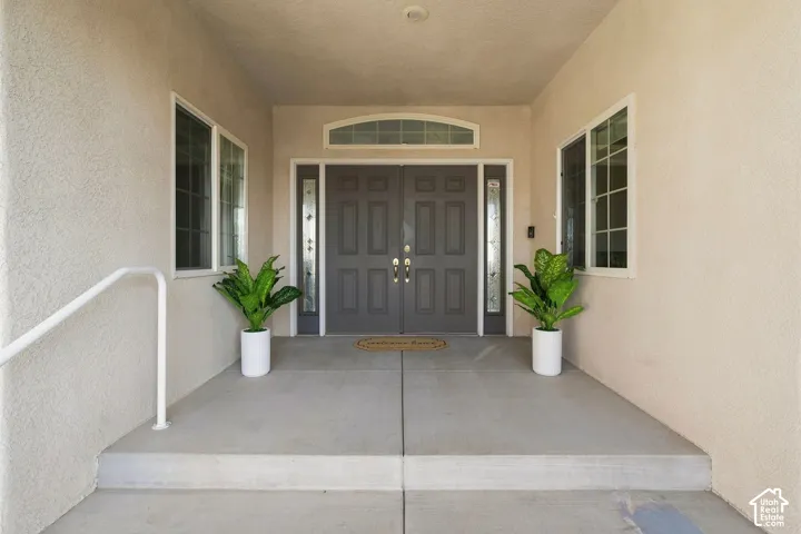 Double entry doors with decorative glass panels, transom window, and dual side windows