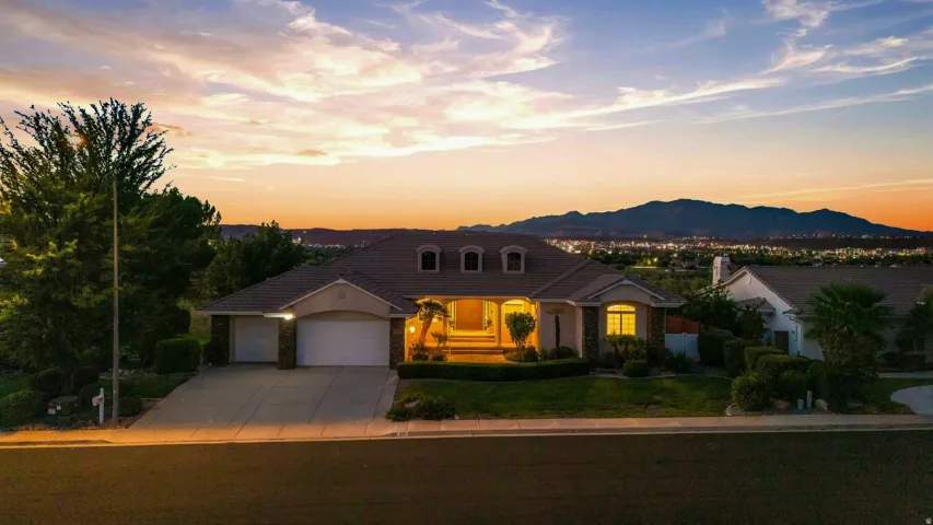 Single-story residence featuring a two-car garage, manicured landscaping, and a paved driveway
