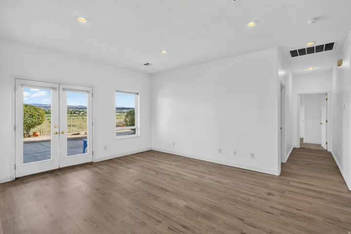 Wood-finish flooring, recessed lighting, and white walls with baseboards