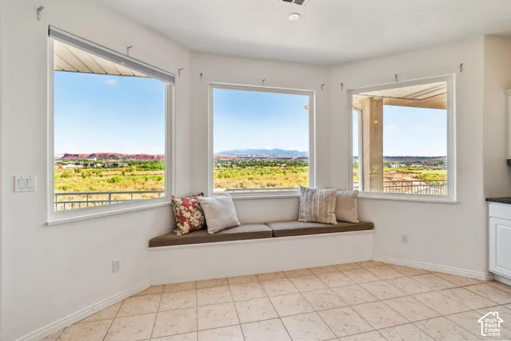 Bright corner room with three large picture windows framing panoramic vistas of rolling hills and open landscape