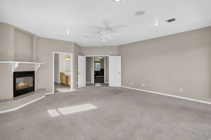 Spacious primary living area with neutral wall finishes, ceiling fan, and recessed lighting throughout