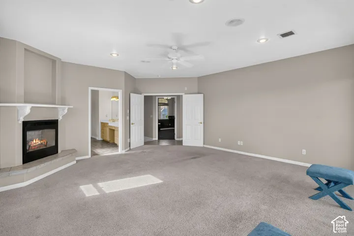 Spacious room featuring a fireplace with a mantel, ceiling fan, and recessed lighting