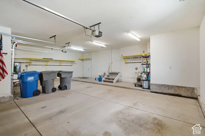 Spacious garage featuring concrete flooring and exposed ceiling beams