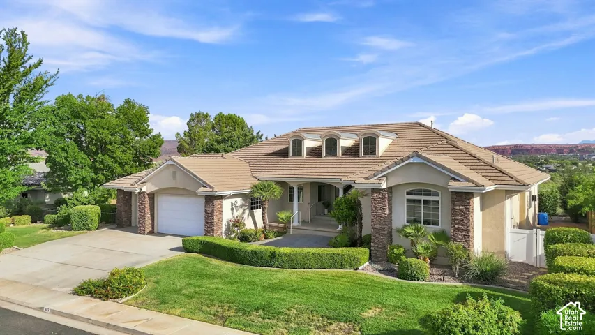 Stone-accented exterior with a tiled roof, multiple dormer windows, and an arched entry